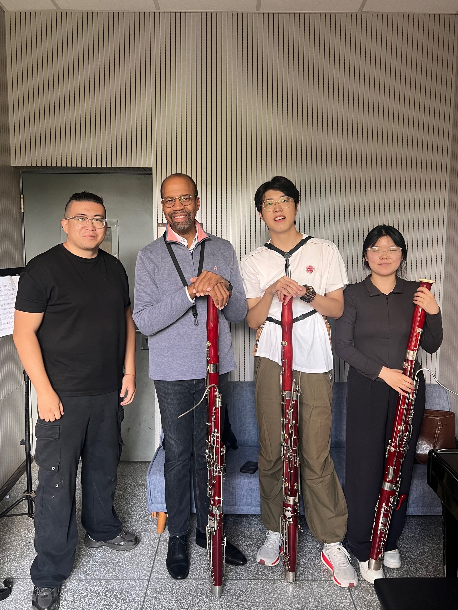 Bryan pose avec des membres de la classe de basson de l’Université des arts du Yunnan; trois personnes tiennent un basson.